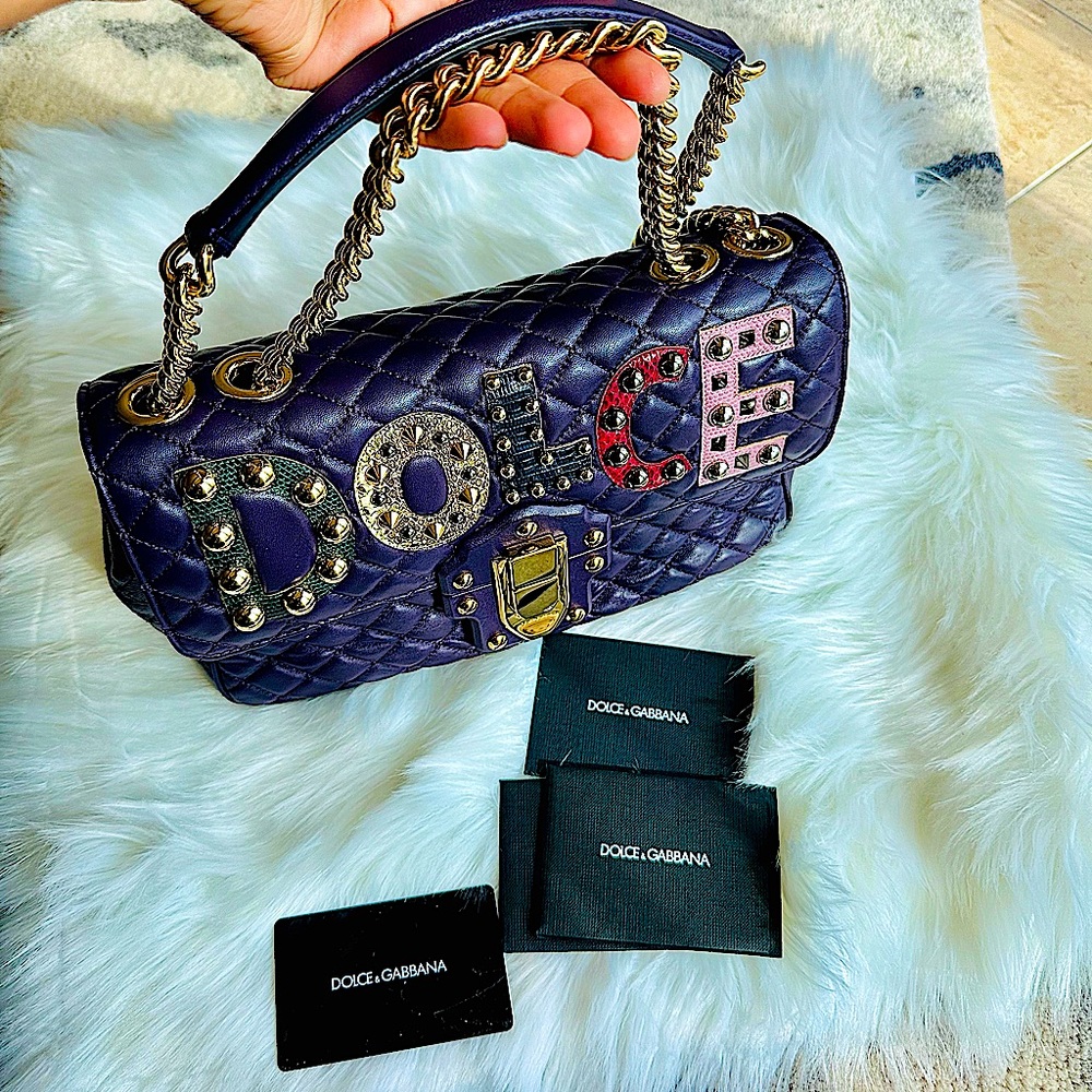 A Dolce & Gabbana hand bag with an embroidered logo in metallic accents..
